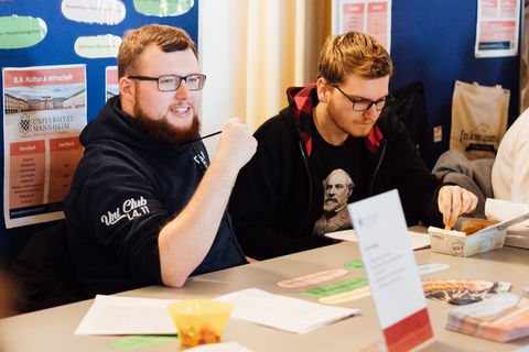 Studierende an einem Infotisch beim Studieninfotag